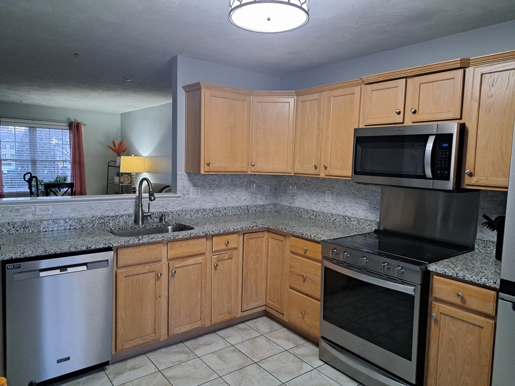 3 Boxberry Lane, Unit 3 Rockland, MA 02370 - Photo 4 of 18 a kitchen with granite countertop a stove sink and microwave