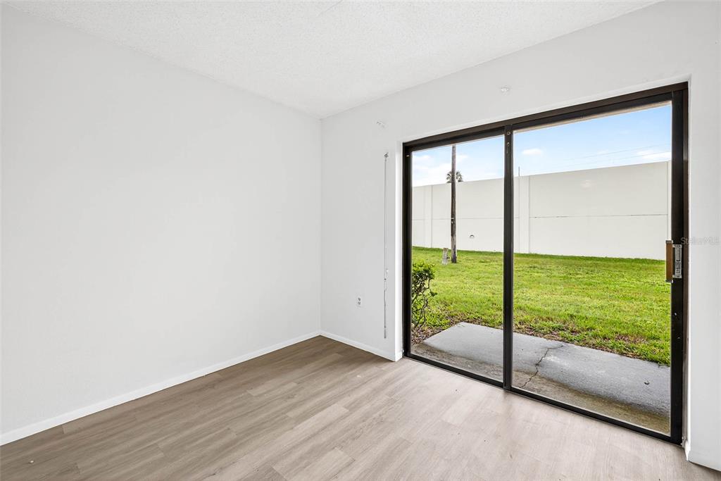 13250 Ridge Road, Unit 21 Largo, FL 33778 - Photo 21 of 36 a view of an empty room with wooden floor and windows