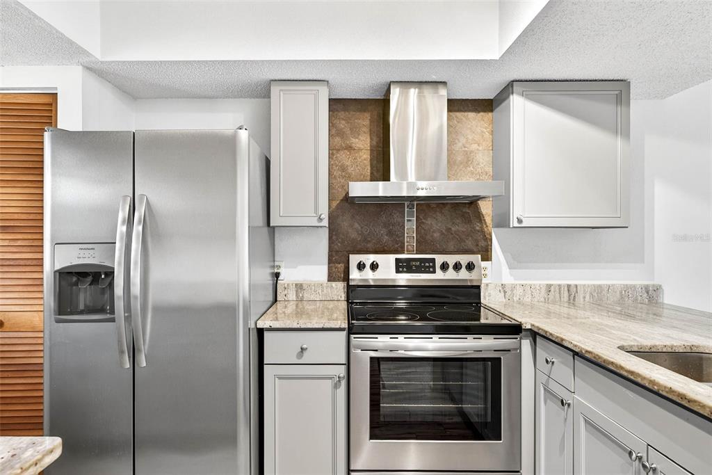 13250 Ridge Road, Unit 21 Largo, FL 33778 - Photo 29 of 36 a kitchen with a stove microwave and refrigerator