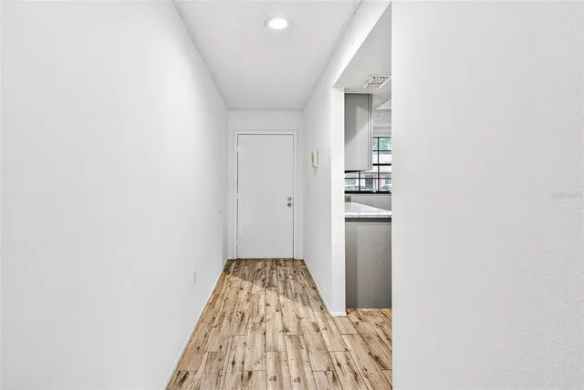 a view of a hallway with wooden floor and staircase