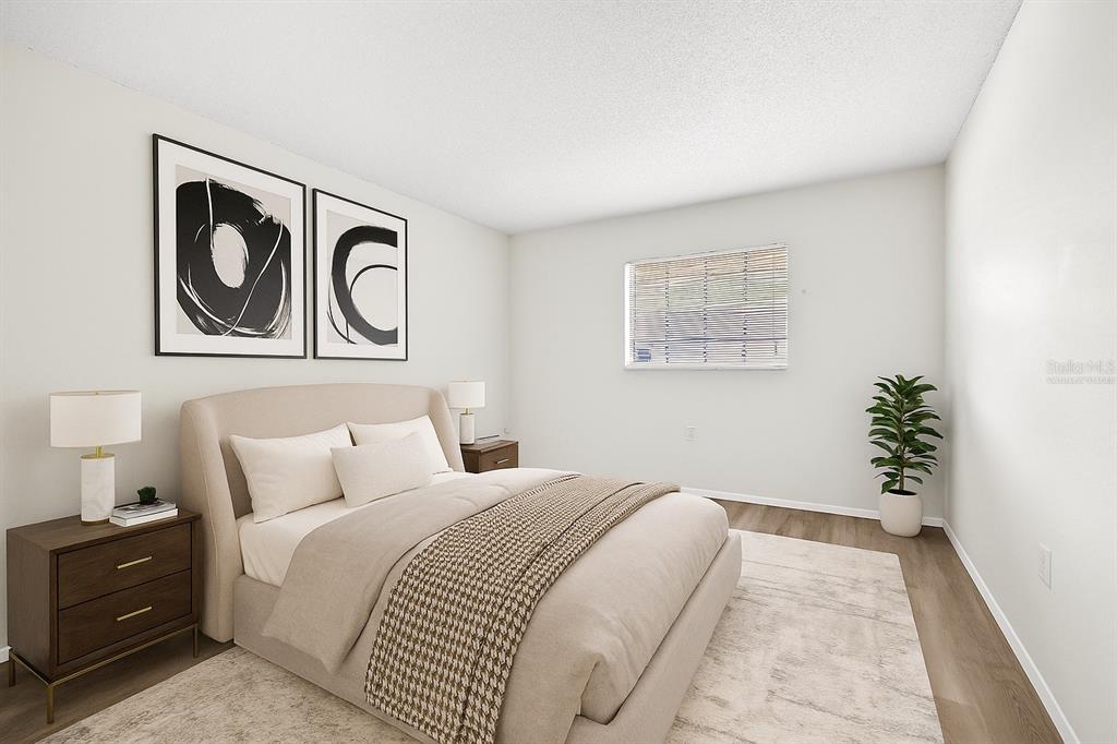 13250 Ridge Road, Unit 21 Largo, FL 33778 - Photo 5 of 36 a bedroom with a bed and a painting on the wall