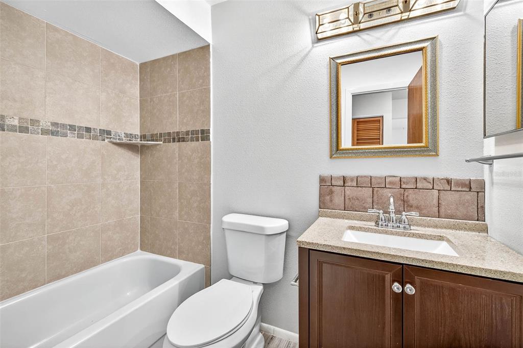 13250 Ridge Road, Unit 21 Largo, FL 33778 - Photo 9 of 36 a bathroom with a sink a toilet and shower