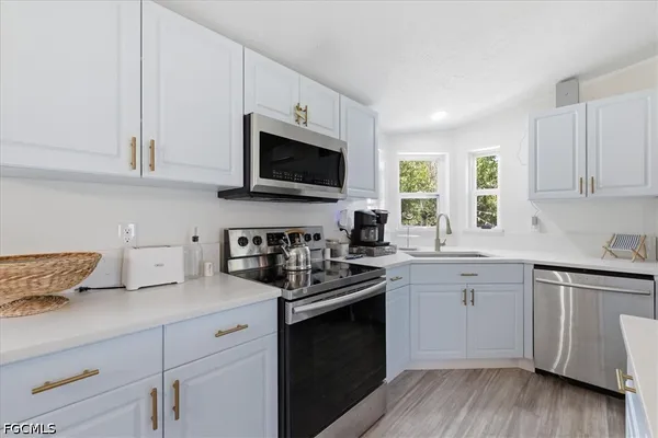 a kitchen with stainless steel appliances granite countertop a refrigerator a stove a microwave oven a dining table and chairs with wooden floor