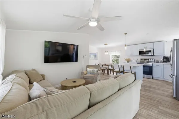 a living room with furniture flat screen tv and a large window