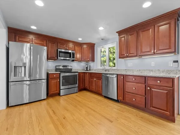 a kitchen with granite countertop stainless steel appliances and wooden cabinets