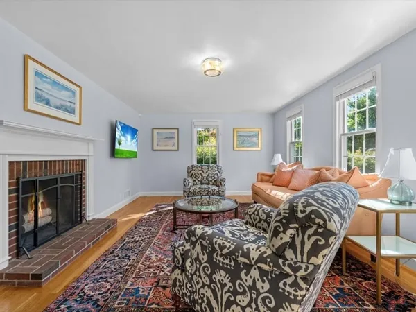 a living room with furniture two window and a fireplace