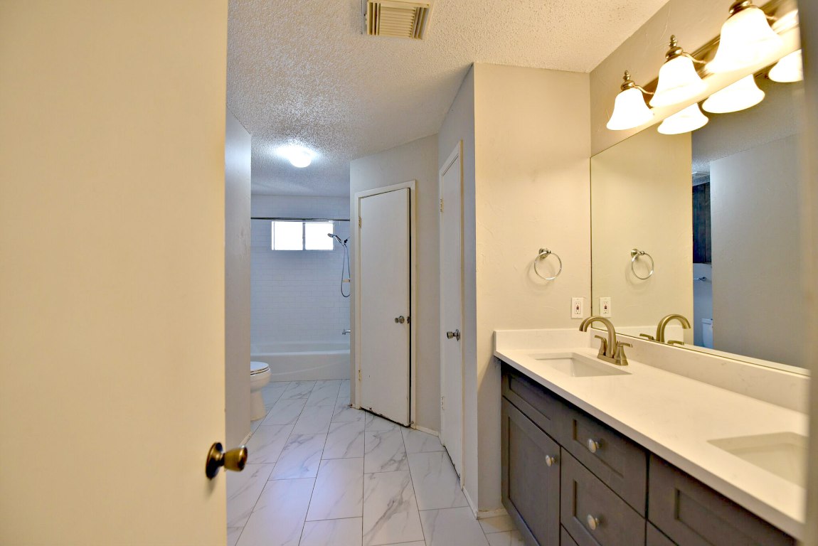 12903 Humphrey Drive Austin, TX 78729 - Photo 13 of 20 a bathroom with a double vanity sink and a mirror