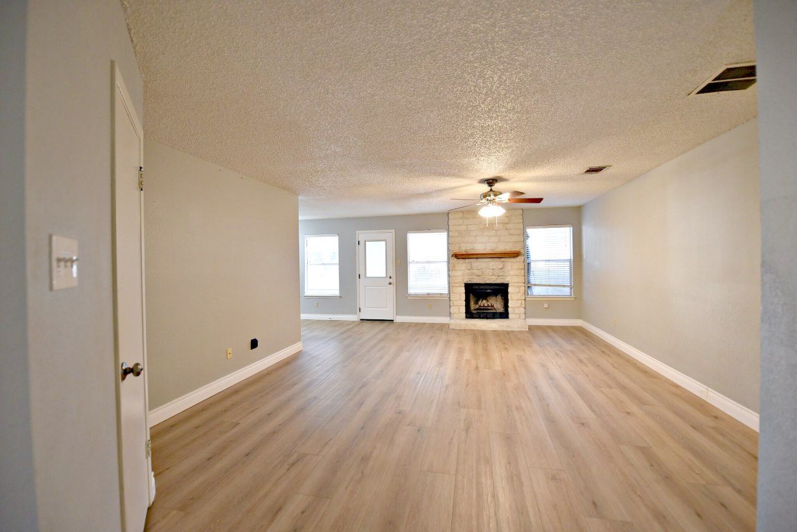 12903 Humphrey Drive Austin, TX 78729 - Photo 5 of 20 a view of an empty room with a fireplace and a window