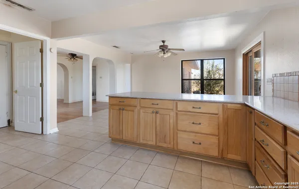 a large kitchen with stainless steel appliances a stove a refrigerator a sink a microwave and dining table
