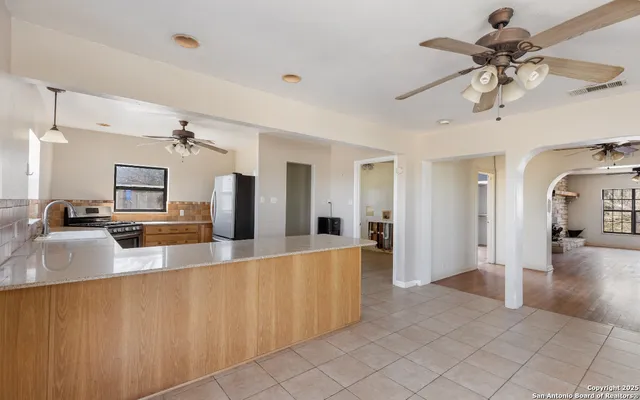 a view of a hallway with wooden floor and a chandelier