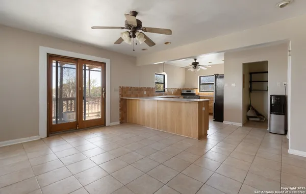 a view of an empty room with wooden floor fireplace and a window