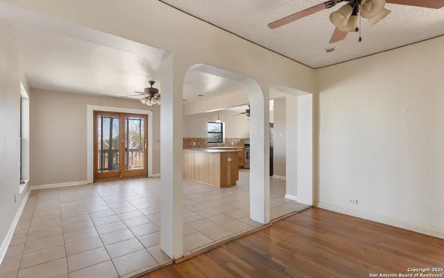 an empty room with windows fireplace and wooden floor