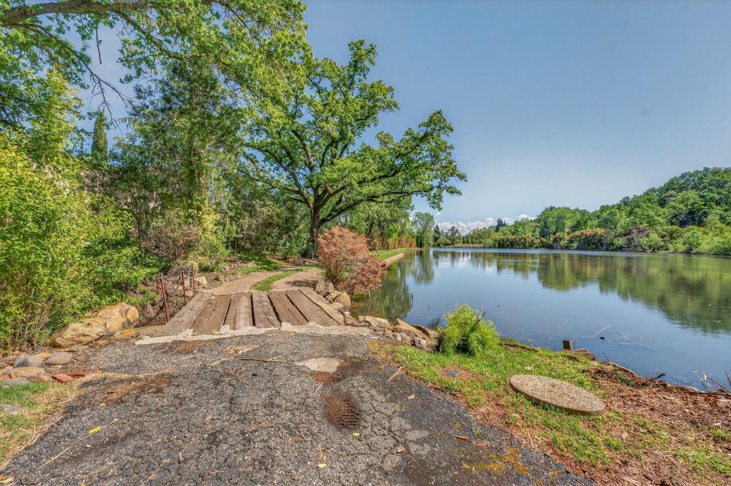 10665 Mt Vernon Road Auburn, CA 95603 - Photo 12 of 45 a view of a lake with a yard and large trees