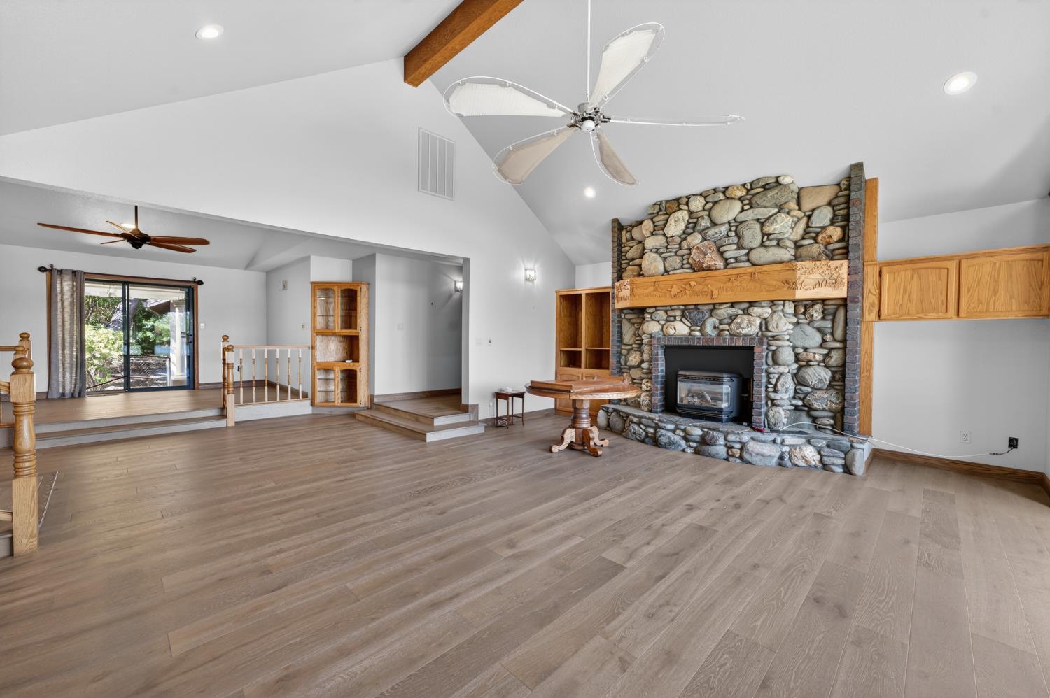 10665 Mt Vernon Road Auburn, CA 95603 - Photo 23 of 45 an empty room with windows fireplace and wooden floor