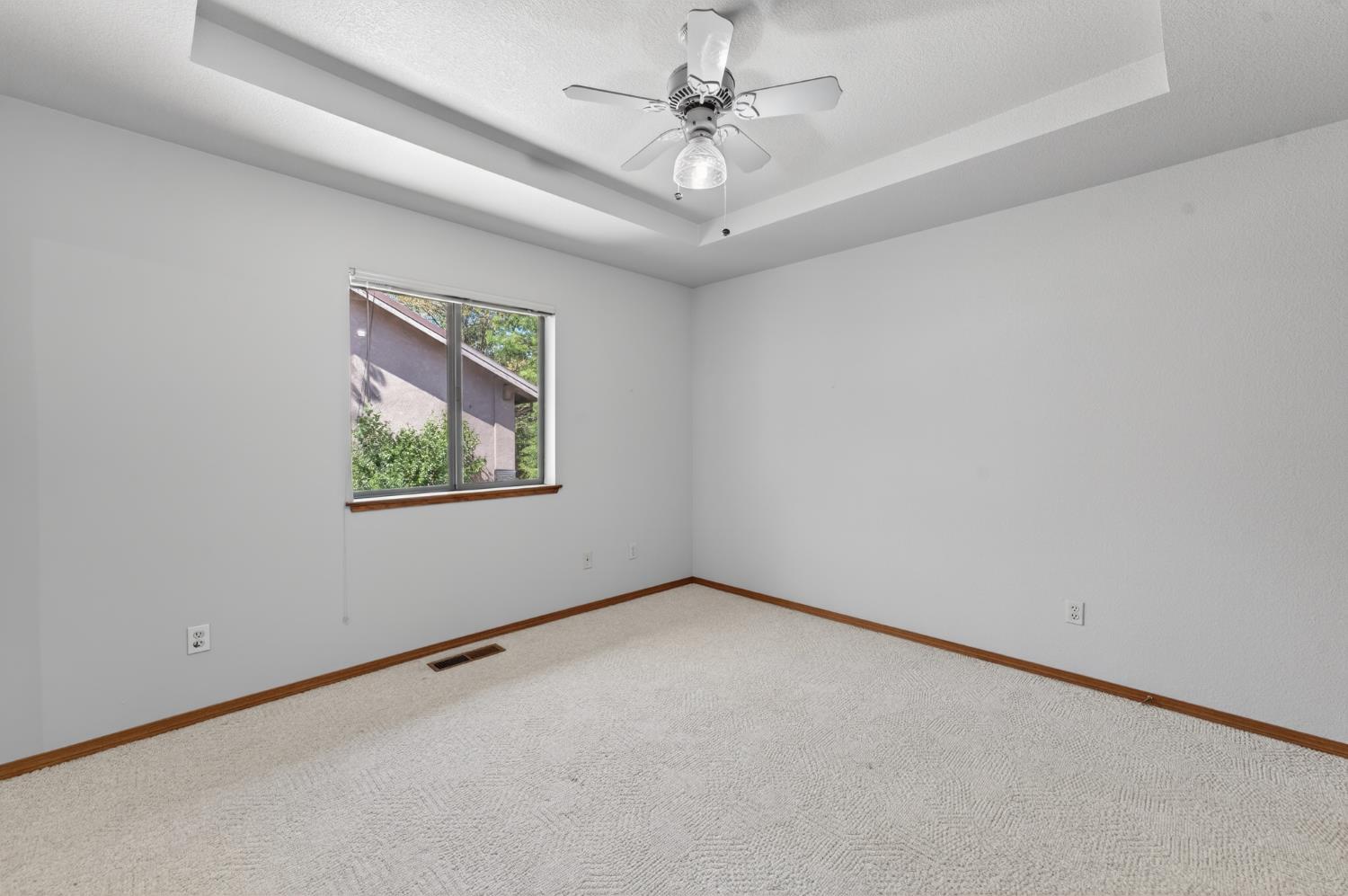 10665 Mt Vernon Road Auburn, CA 95603 - Photo 34 of 45 an empty room with a chandelier fan and windows