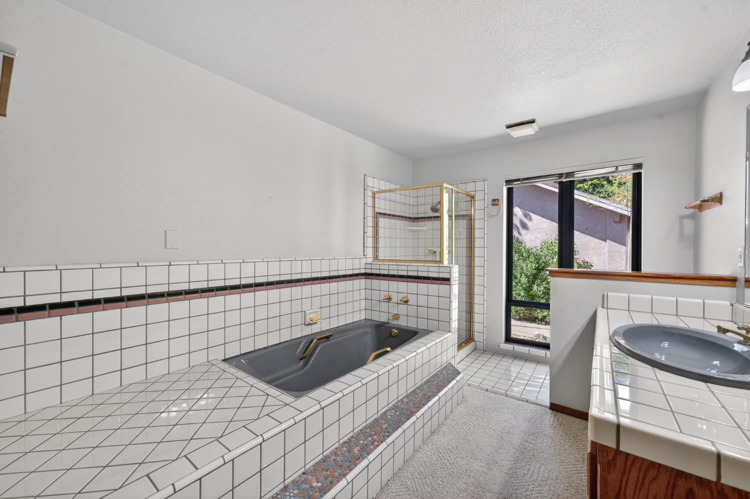 10665 Mt Vernon Road Auburn, CA 95603 - Photo 35 of 45 a bathroom with a tub a sink and a large window