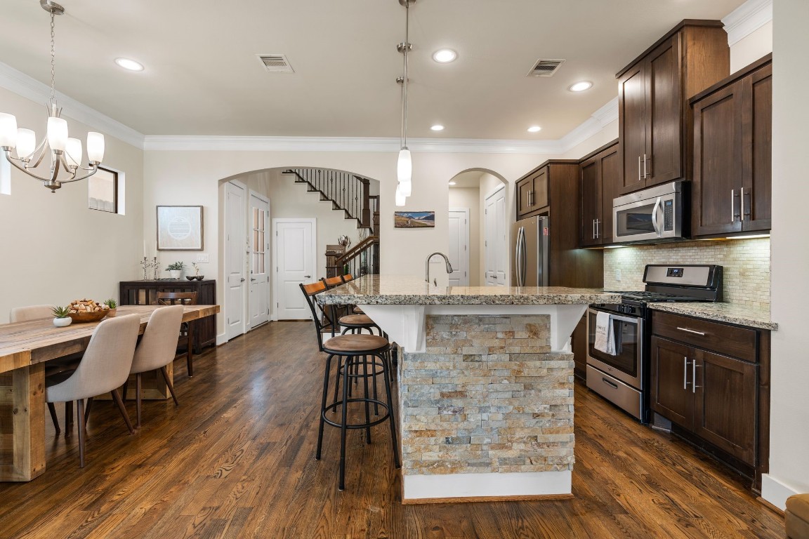 4205 Koehler Street, Unit B Houston, TX 77007 - Photo 6 of 28 a kitchen with stainless steel appliances kitchen island granite countertop a stove and a wooden floors
