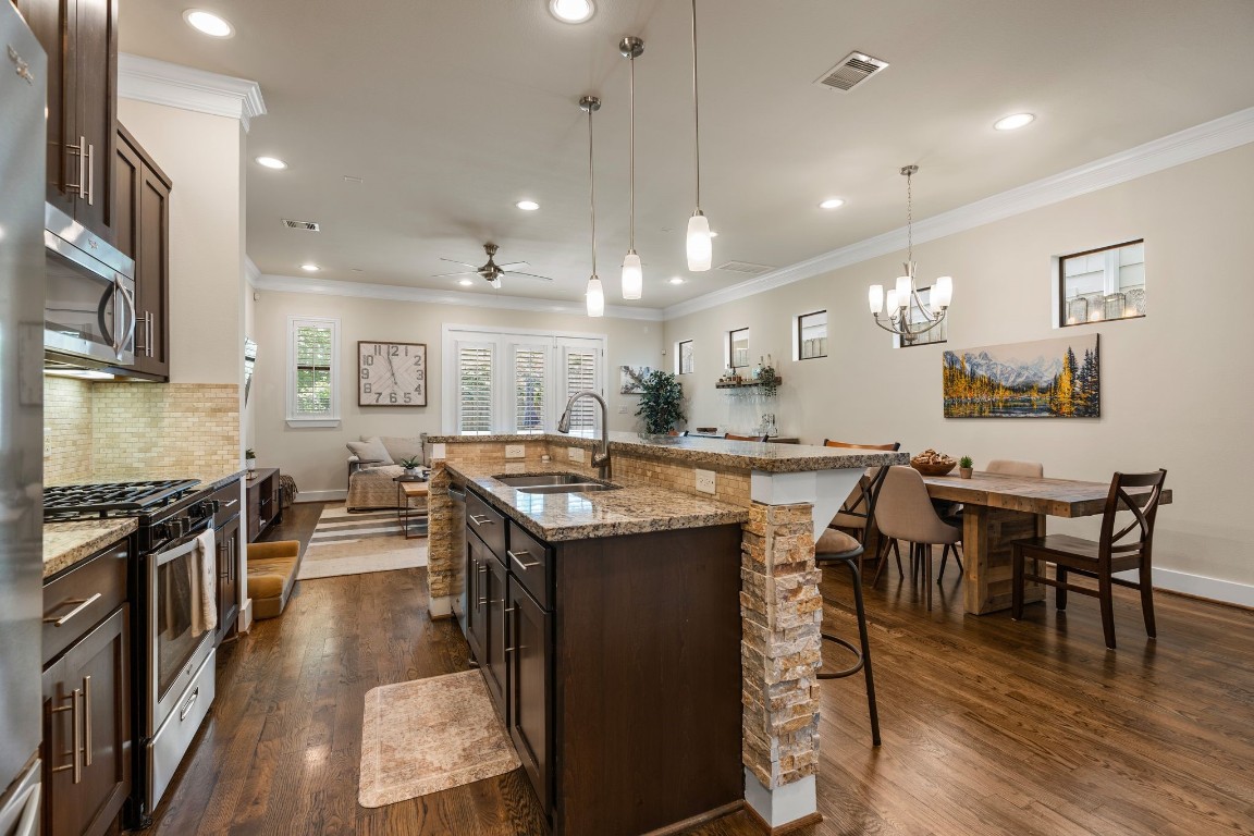 4205 Koehler Street, Unit B Houston, TX 77007 - Photo 7 of 28 a kitchen with stainless steel appliances granite countertop a stove top oven a dining table and chairs with wooden floor