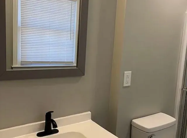 a bathroom with a toilet a sink and a window