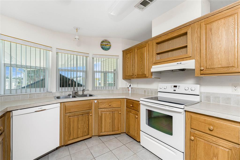 1891 Englewood Road, Unit 81 Englewood, FL 34223 - Photo 12 of 53 a kitchen with a sink stove and cabinets