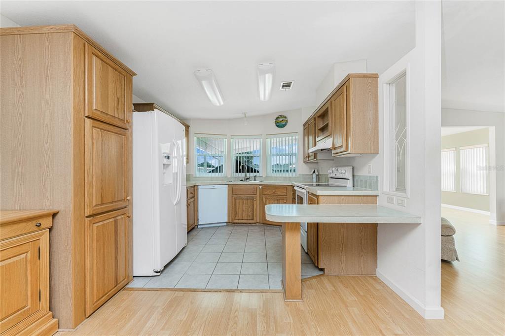 1891 Englewood Road, Unit 81 Englewood, FL 34223 - Photo 13 of 53 a kitchen with stainless steel appliances granite countertop a refrigerator a sink a stove and white cabinets with wooden floor