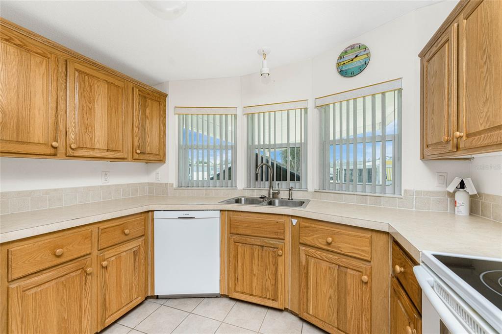 1891 Englewood Road, Unit 81 Englewood, FL 34223 - Photo 14 of 53 a kitchen with sink cabinets and window