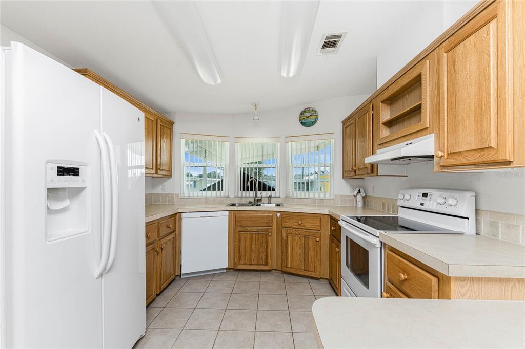 1891 Englewood Road, Unit 81 Englewood, FL 34223 - Photo 15 of 53 a kitchen with a sink stove and cabinets