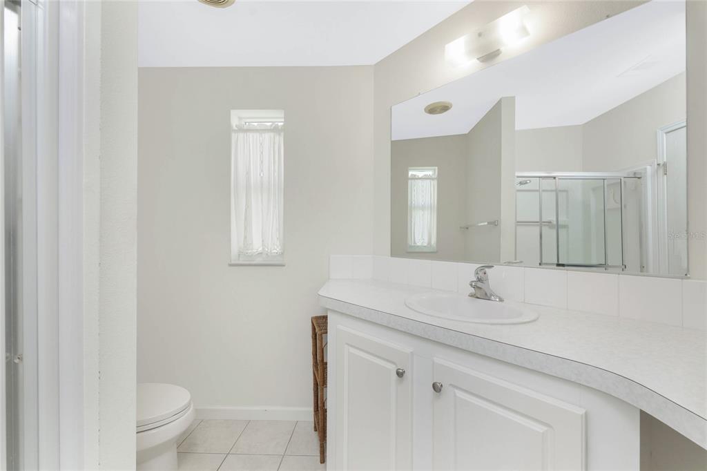 1891 Englewood Road, Unit 81 Englewood, FL 34223 - Photo 27 of 53 a bathroom with a sink a toilet and a mirror