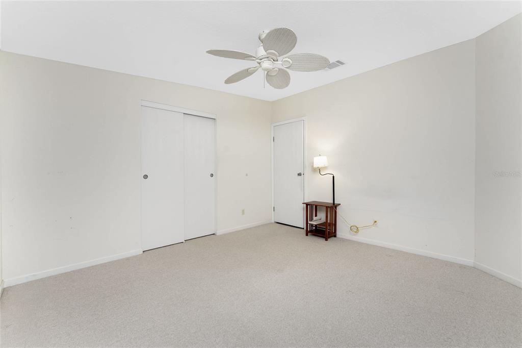 1891 Englewood Road, Unit 81 Englewood, FL 34223 - Photo 31 of 53 an empty room with ceiling fan and window