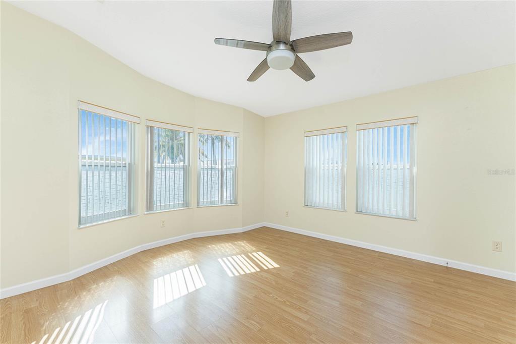 1891 Englewood Road, Unit 81 Englewood, FL 34223 - Photo 7 of 53 an empty room with wooden floor fan and windows