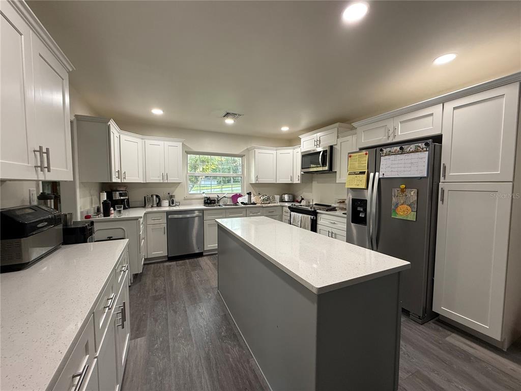 1021 Southwest 26th Street Ocala, FL 34471 - Photo 5 of 10 a kitchen with a refrigerator a sink and cabinets