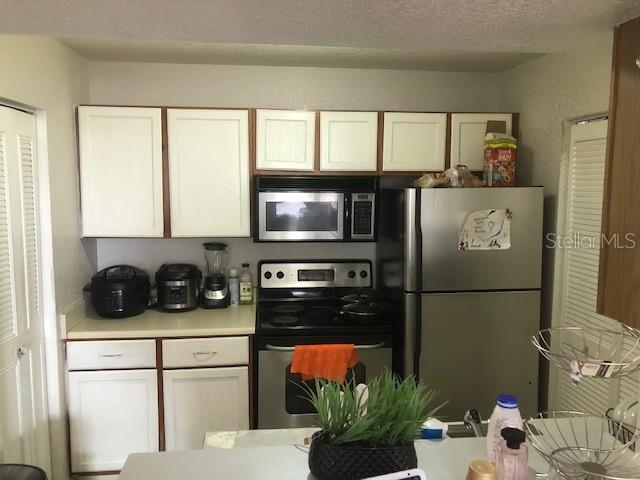 1025 South Hiawassee Road, Unit 2226 Orlando, FL 32835 - Photo 6 of 7 a kitchen with stainless steel appliances a refrigerator sink and cabinets