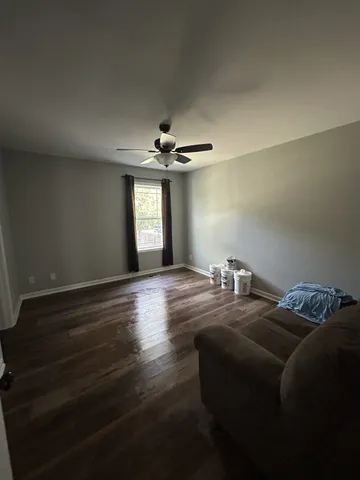 a room with wooden floor and a ceiling fan