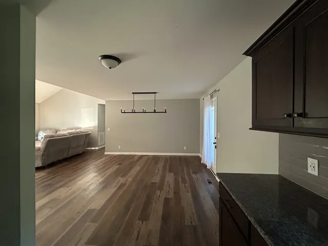 a view of a livingroom with wooden floor and staircase