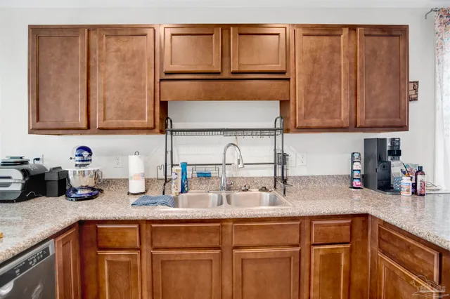 a kitchen with granite countertop a sink and cabinets