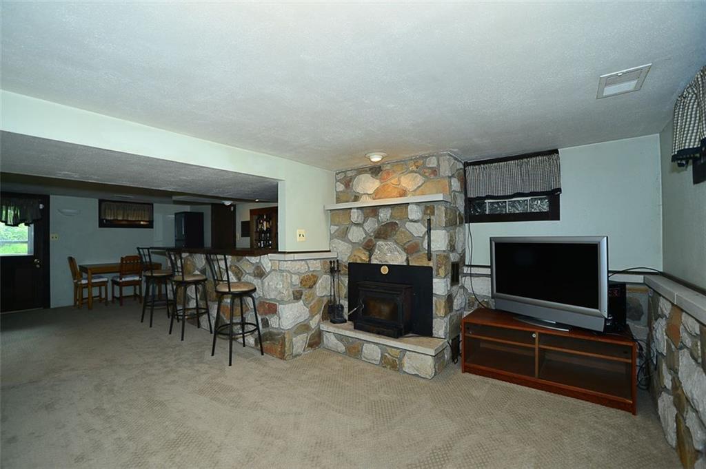 12780 Ridge Road North Huntingdon, PA 15642 - Photo 11 of 21 So many great features in this room made for entertaining and relaxing! New carpet provides a fresh look for the lower level living room and bar area. The stone adds so much character to the wood burning stove in this space. It also provides easy access to the back yard!