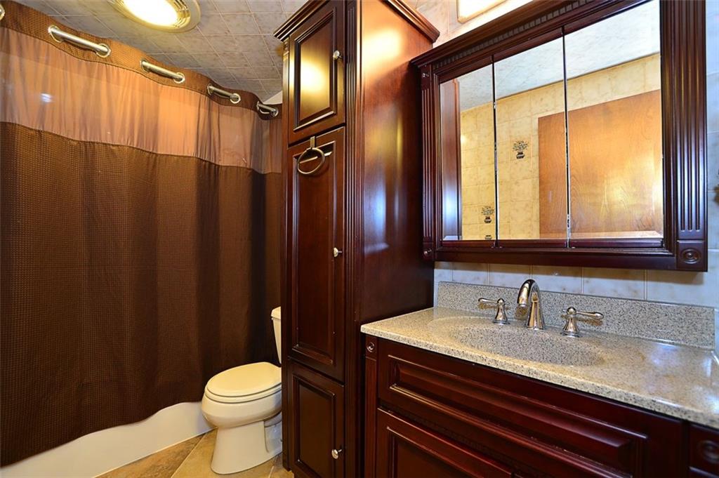 12780 Ridge Road North Huntingdon, PA 15642 - Photo 9 of 21 This full bathroom has exquisite wood cabinetry and new tile flooring as well as plenty of storage.