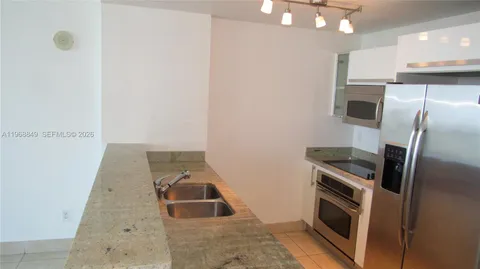 a kitchen with a sink and stainless steel appliances