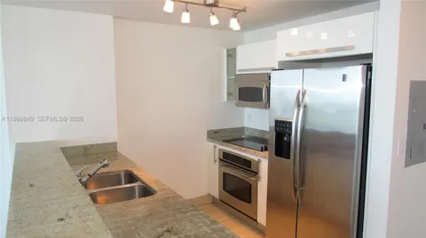 a kitchen with stainless steel appliances granite countertop a refrigerator and a sink