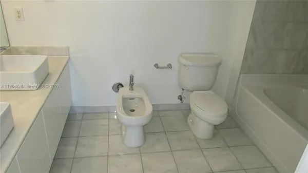 a white toilet sitting next to a bath tub
