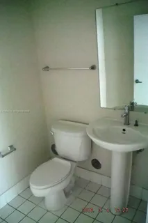 a white toilet sitting next to a bathroom sink