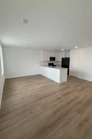 a view of a kitchen with kitchen island a sink wooden floor and counter top space