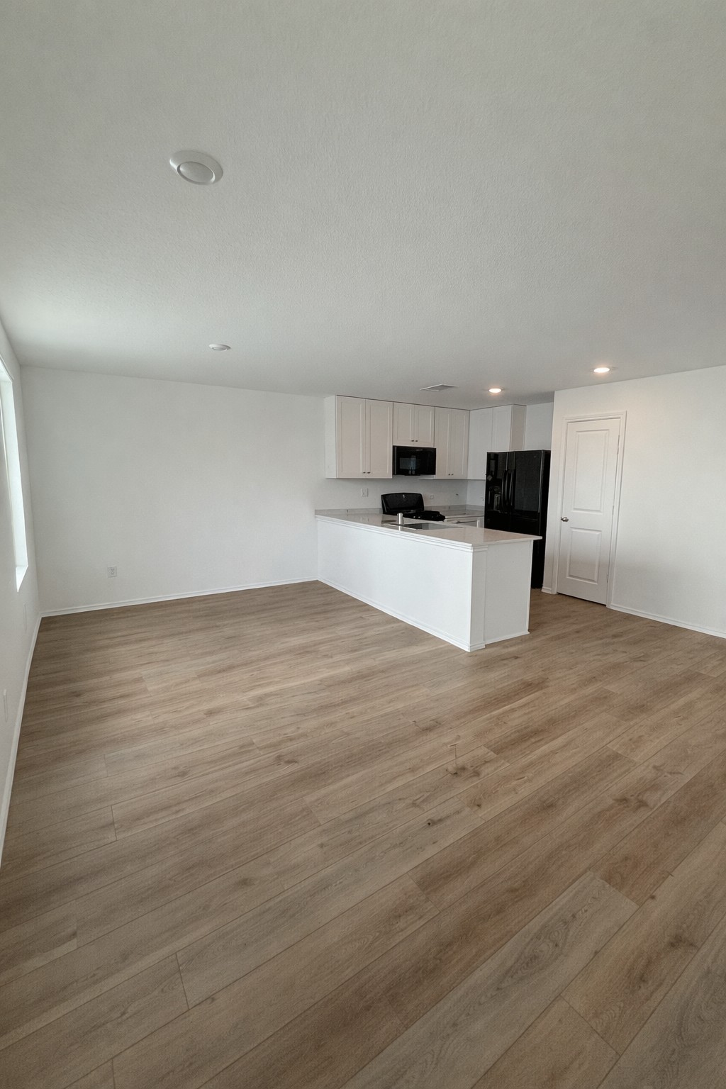 23408 Tiny Moons Way Elgin, TX 78621 - Photo 3 of 11 a view of a kitchen with kitchen island a sink wooden floor and counter top space