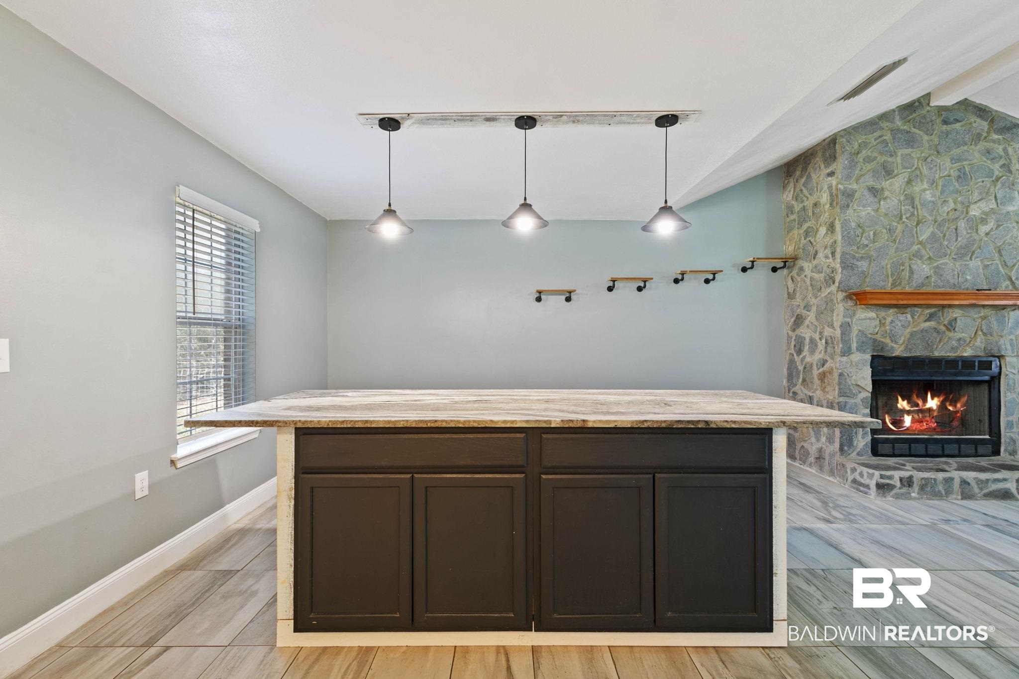17366 Old Brady Road Bay Minette, AL 36507 - Photo 12 of 43 Kitchen with vaulted ceiling, a fireplace, decorative light fixtures, a center island, and dark brown cabinetry