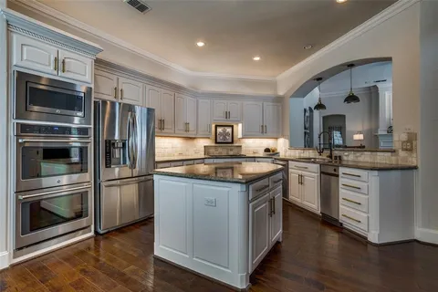 a kitchen with granite countertop stainless steel appliances and wooden cabinets