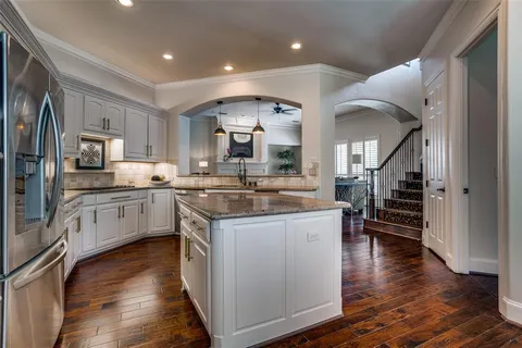 a kitchen with stainless steel appliances kitchen island granite countertop a stove a sink and a refrigerator