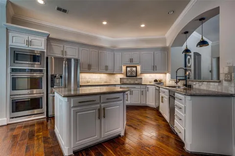 a kitchen with stainless steel appliances granite countertop a refrigerator and a stove top oven