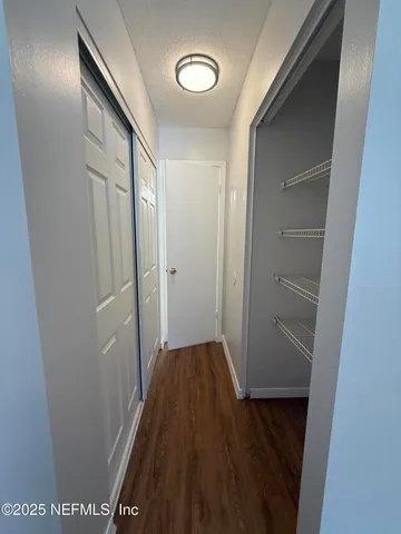 a view of a hallway with wooden floor