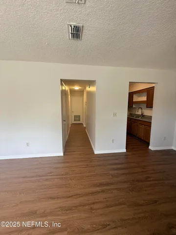 a view of empty room with wooden floor