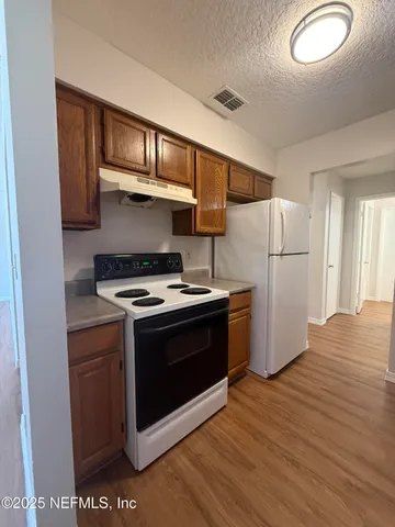 a kitchen with a stove a refrigerator and a microwave